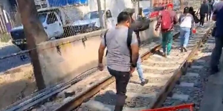 Falla en el tren ligero obliga a usuarios a caminar sobre las vías